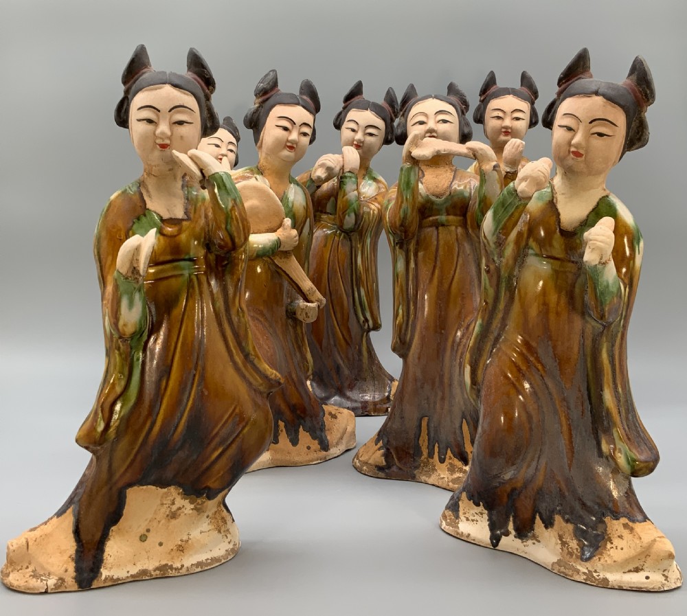 A set of seven Tang dynasty style lead-glazed earthenware figurines depicting standing female court musicians holding traditional instruments. View XIV
