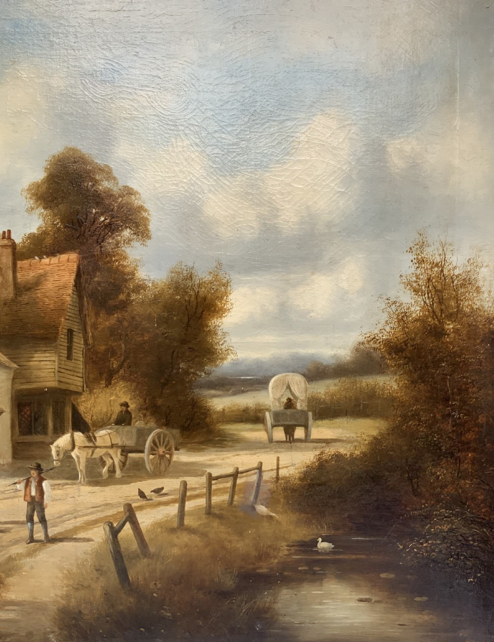 A 19th-century oil painting depicting a rural English village with horses, figures, and cottages on a dirt road, set in a carved gilded frame. View IV