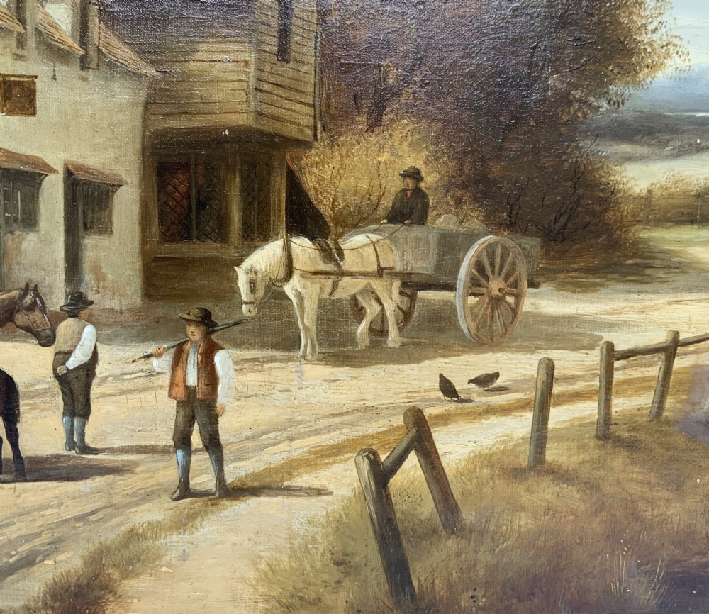 A 19th-century oil painting depicting a rural English village with horses, figures, and cottages on a dirt road, set in a carved gilded frame. View X