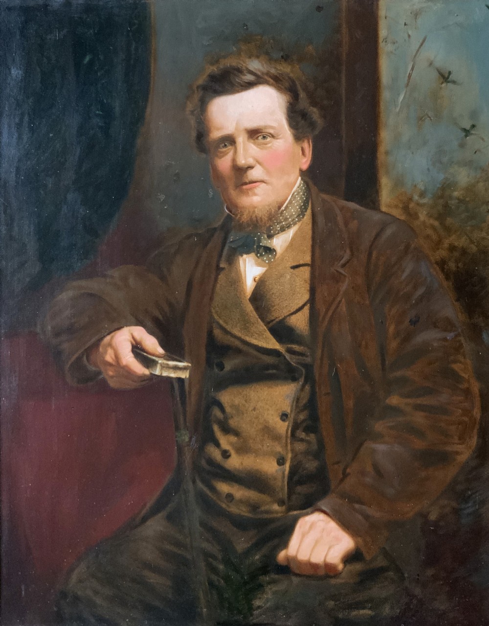 A 19th-century oil painting depicting a seated gentleman in a brown coat and waistcoat holding a small book, encased in an ornate gilded frame. View III