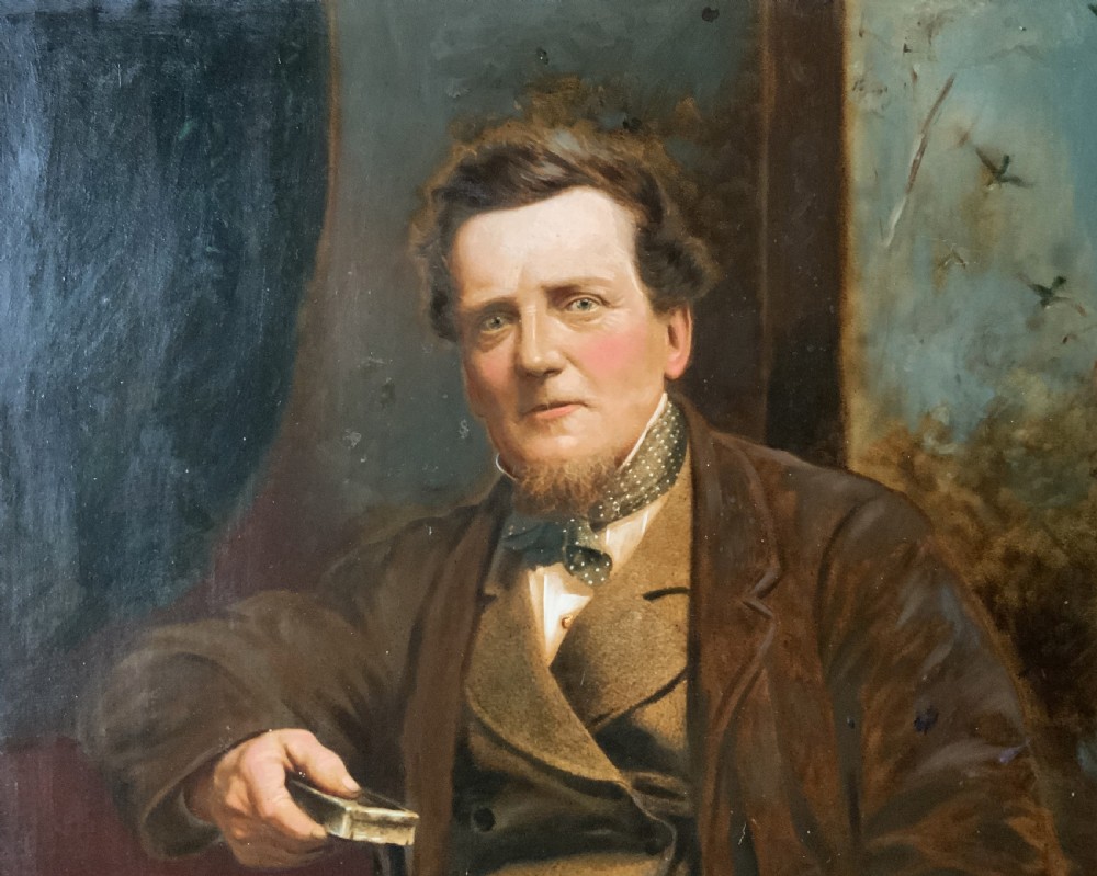 A 19th-century oil painting depicting a seated gentleman in a brown coat and waistcoat holding a small book, encased in an ornate gilded frame. View VI