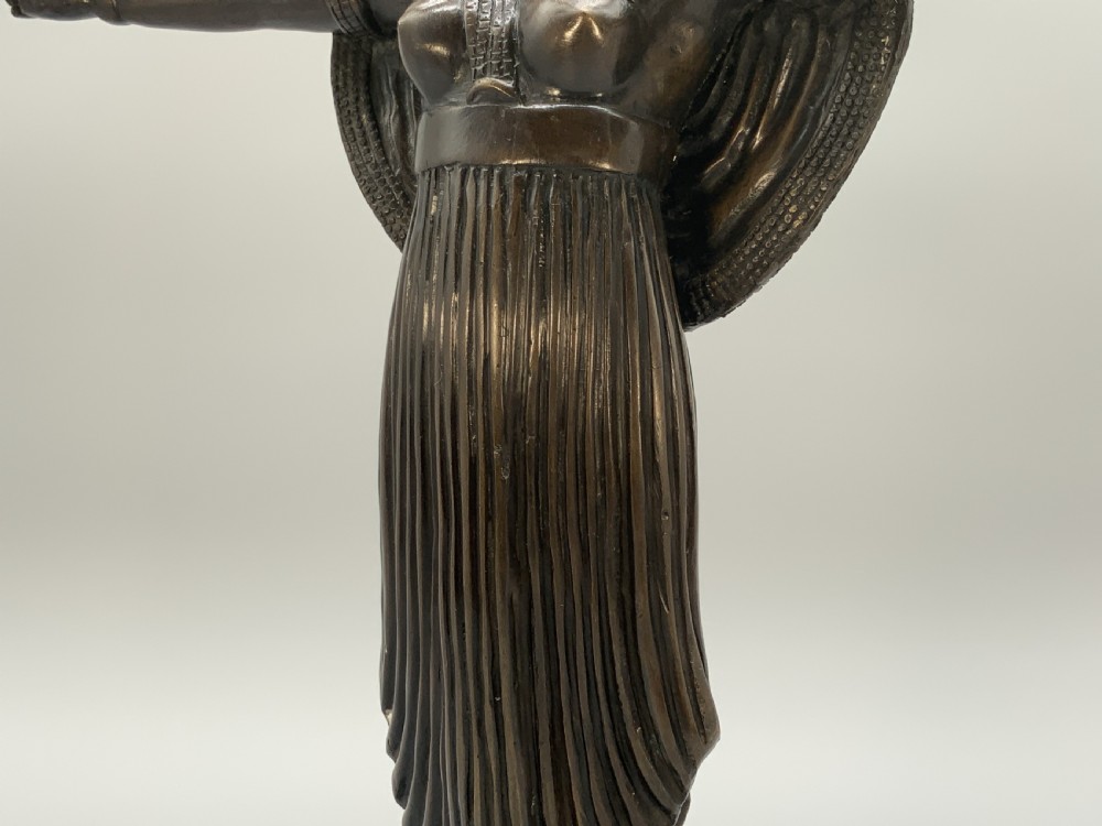 A patinated bronze Egyptian Revival candelabra featuring a female figure with outstretched arms holding two candle sockets, standing on a decorated triangular base. View XI