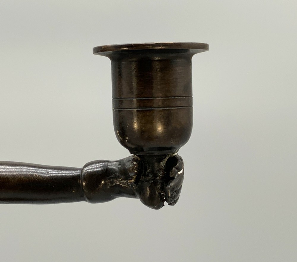 A patinated bronze Egyptian Revival candelabra featuring a female figure with outstretched arms holding two candle sockets, standing on a decorated triangular base. View XVI