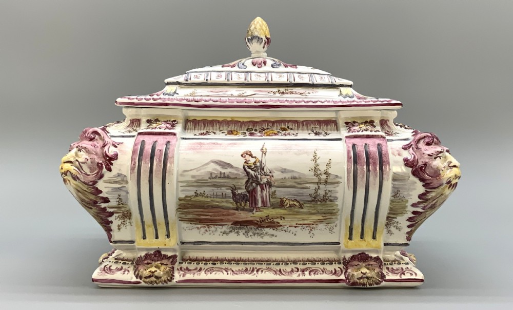 An antique French faience covered soup tureen featuring hand-painted pastoral scenes in manganese purple, moulded lion mask side handles, and a stepped lid with a finial. View XVII