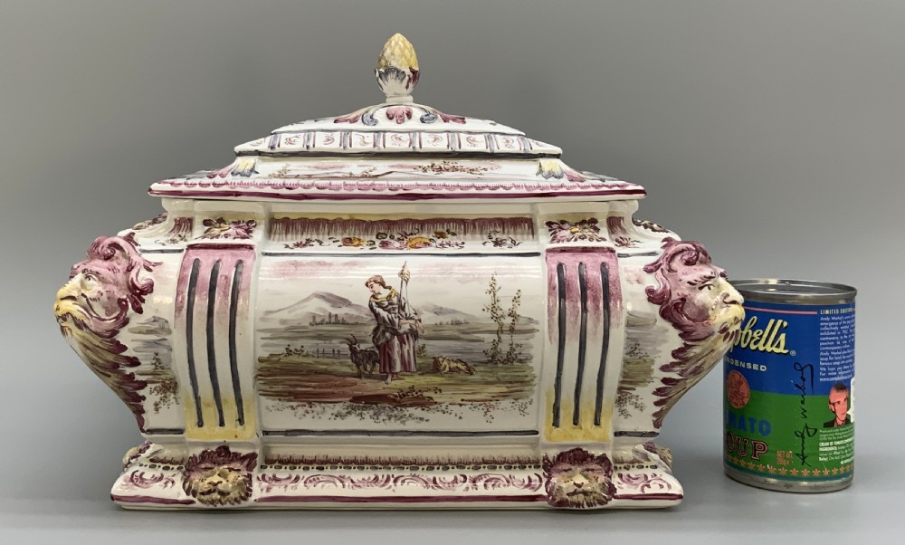 An antique French faience covered soup tureen featuring hand-painted pastoral scenes in manganese purple, moulded lion mask side handles, and a stepped lid with a finial. View III