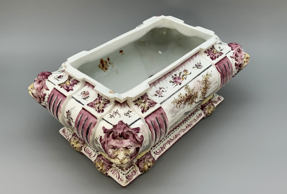 An antique French faience covered soup tureen featuring hand-painted pastoral scenes in manganese purple, moulded lion mask side handles, and a stepped lid with a finial. View XI