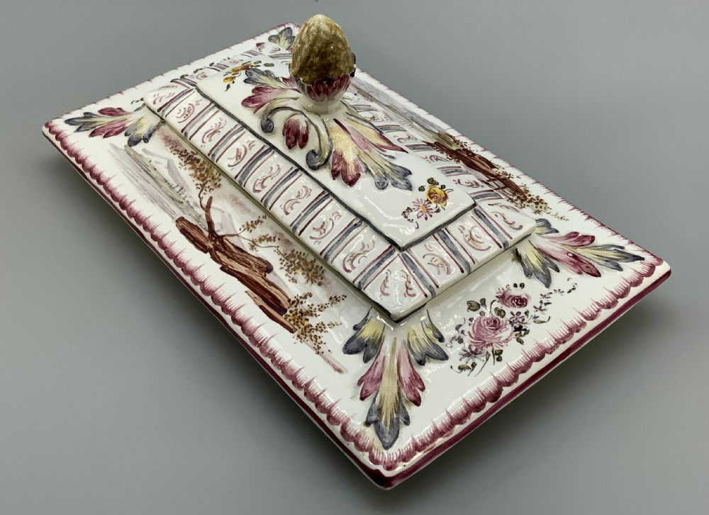 An antique French faience covered soup tureen featuring hand-painted pastoral scenes in manganese purple, moulded lion mask side handles, and a stepped lid with a finial. View XIII