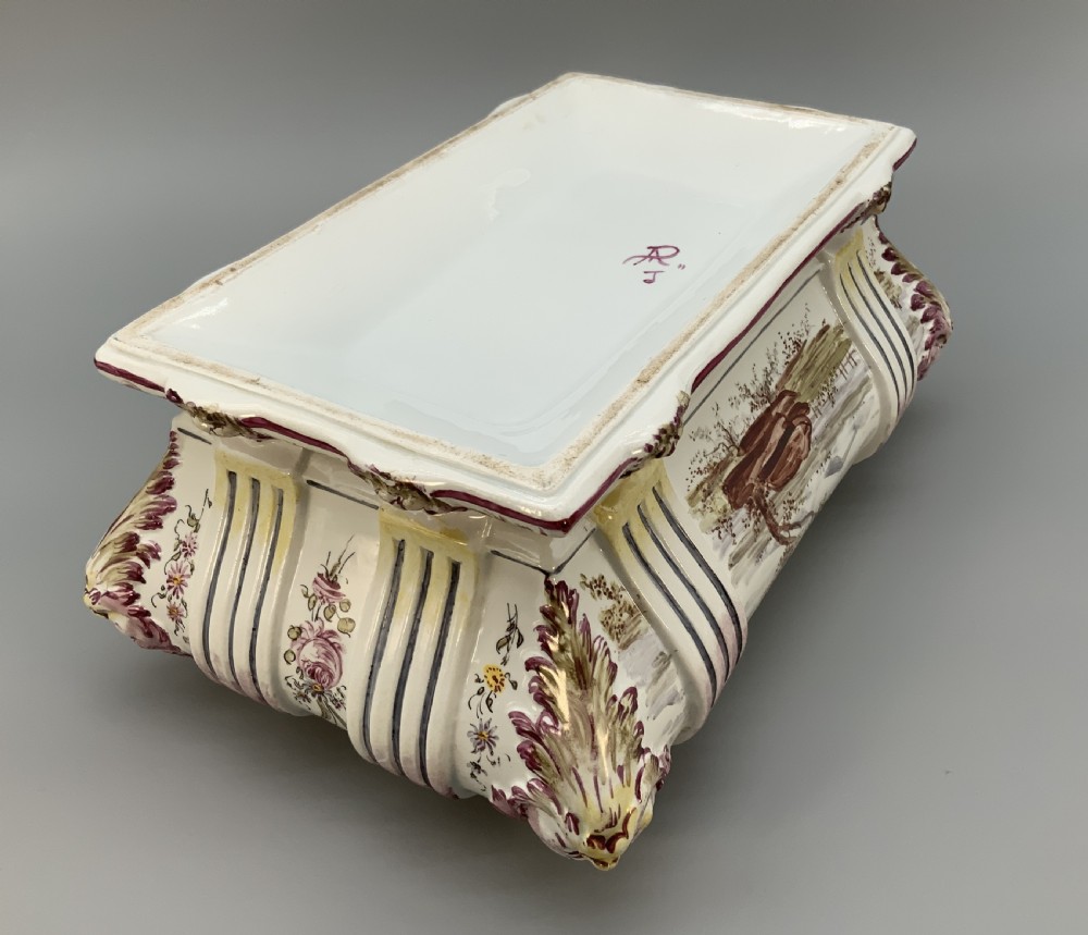 An antique French faience covered soup tureen featuring hand-painted pastoral scenes in manganese purple, moulded lion mask side handles, and a stepped lid with a finial. View XV