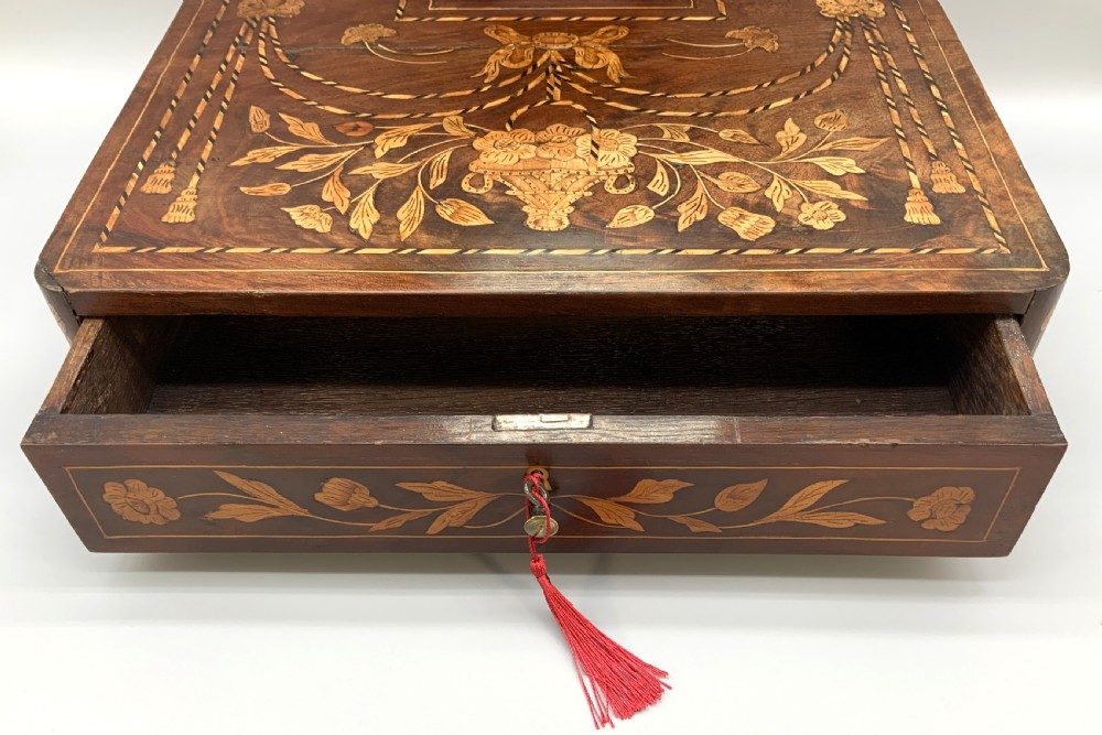 A 19th-century Dutch marquetry toilet mirror featuring a circular swivelling glass frame supported by carved wooden arms above a single base drawer decorated with detailed floral timber inlays. View VI