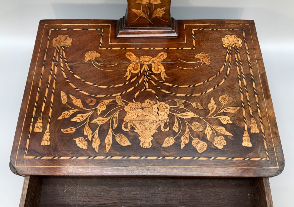 A 19th-century Dutch marquetry toilet mirror featuring a circular swivelling glass frame supported by carved wooden arms above a single base drawer decorated with detailed floral timber inlays. View VII