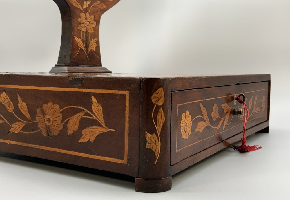 A 19th-century Dutch marquetry toilet mirror featuring a circular swivelling glass frame supported by carved wooden arms above a single base drawer decorated with detailed floral timber inlays. View XI