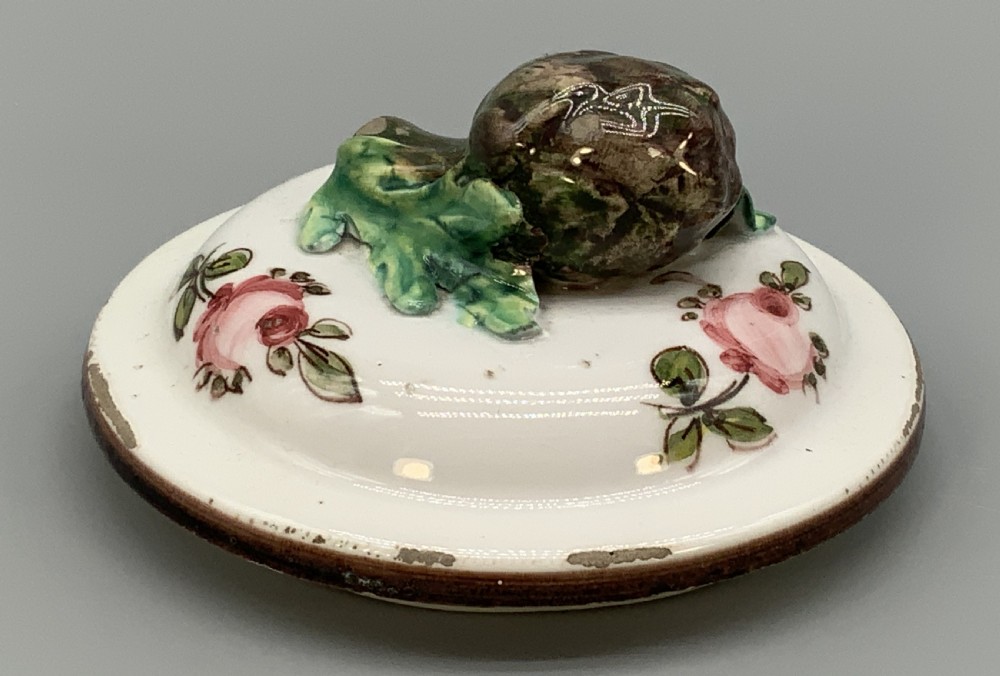 An 18th-century Italian tin-glazed earthenware pharmacy wet drug jug with a spouted body, top handle, lid with sculpted finial, painted armorial crest, floral scrolls, and Latin text reading Syr Alth. View XI