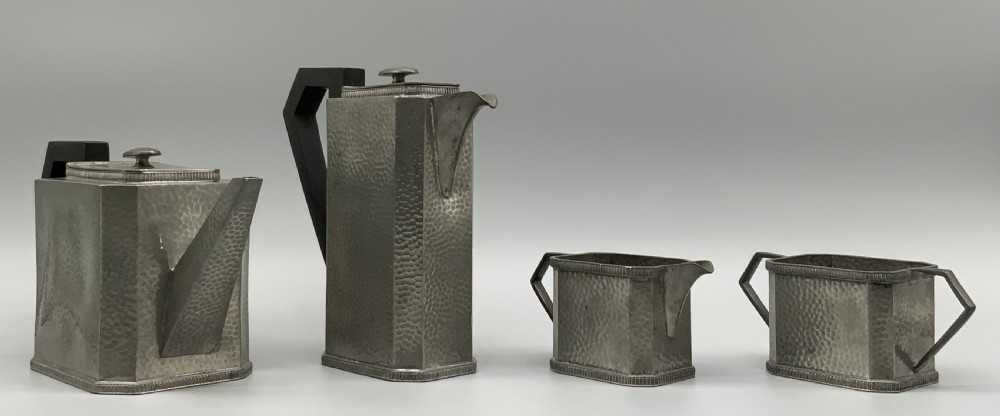 A five-piece Art Deco pewter tea and coffee set featuring a planished finish, geometric handles, and an octagonal tray. View III