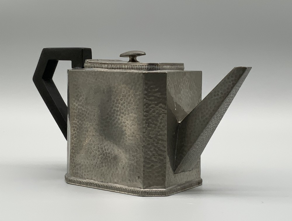 A five-piece Art Deco pewter tea and coffee set featuring a planished finish, geometric handles, and an octagonal tray. View IV