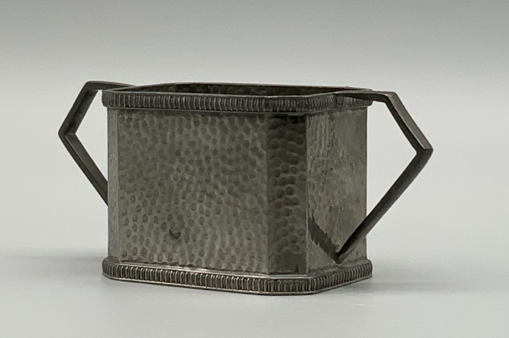 A five-piece Art Deco pewter tea and coffee set featuring a planished finish, geometric handles, and an octagonal tray. View VII