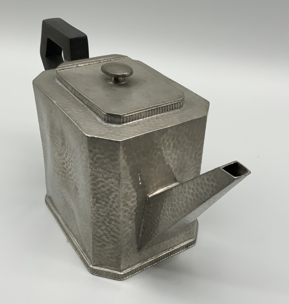 A five-piece Art Deco pewter tea and coffee set featuring a planished finish, geometric handles, and an octagonal tray. View IX