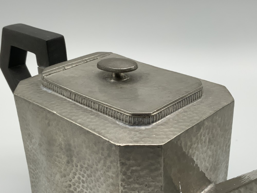 A five-piece Art Deco pewter tea and coffee set featuring a planished finish, geometric handles, and an octagonal tray. View X