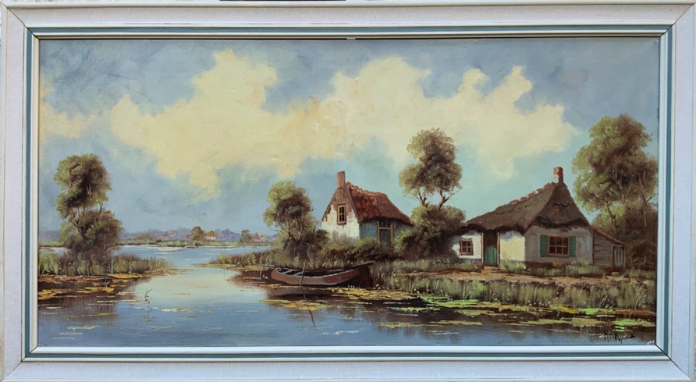 A horizontal mid-century impressionist oil painting depicting a river scene with cottages along the bank under a cloud-filled sky, set within a light-coloured frame.
