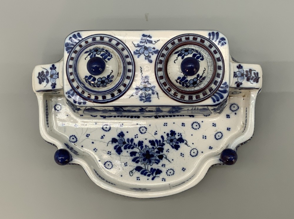 A late nineteenth-century Dutch Delft blue and white ceramic inkstand featuring twin removable lids, an integrated pen tray, and hand-painted windmill landscape scenes. View XI