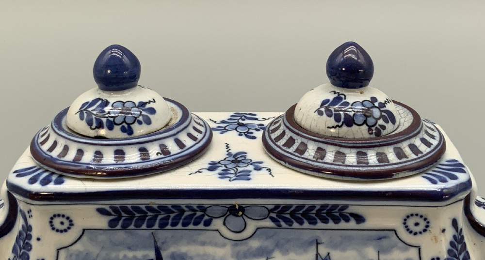 A late nineteenth-century Dutch Delft blue and white ceramic inkstand featuring twin removable lids, an integrated pen tray, and hand-painted windmill landscape scenes. View XII