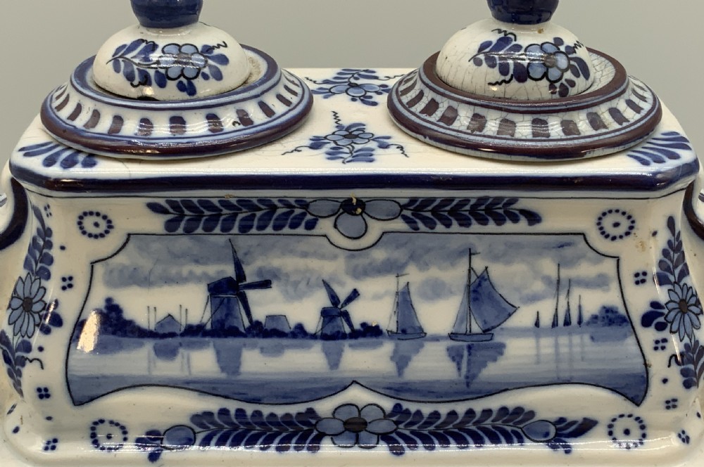 A late nineteenth-century Dutch Delft blue and white ceramic inkstand featuring twin removable lids, an integrated pen tray, and hand-painted windmill landscape scenes. View XIII