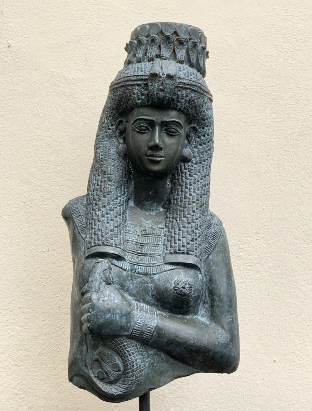 A dark green patinated bronze bust of Cleopatra holding an asp, mounted on a rectangular pink marble base. View VII