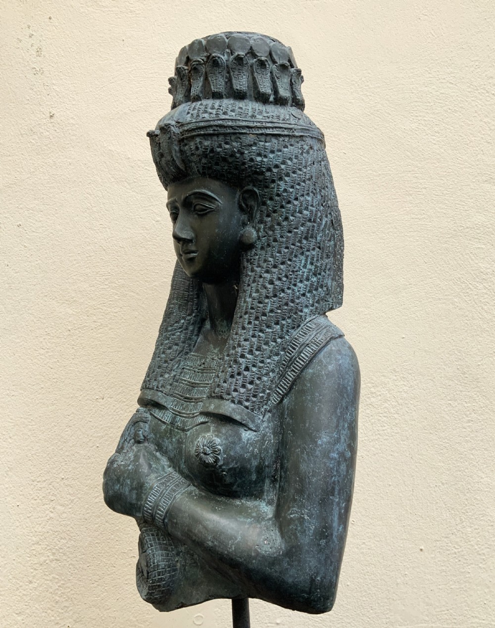 A dark green patinated bronze bust of Cleopatra holding an asp, mounted on a rectangular pink marble base. View IX