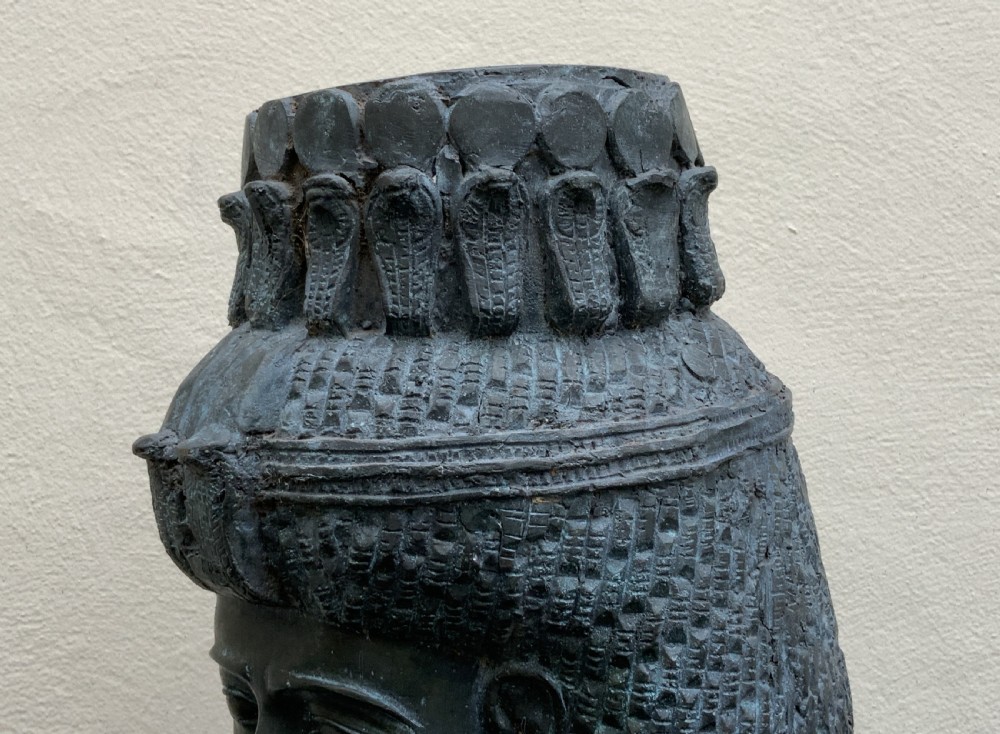 A dark green patinated bronze bust of Cleopatra holding an asp, mounted on a rectangular pink marble base. View XIV