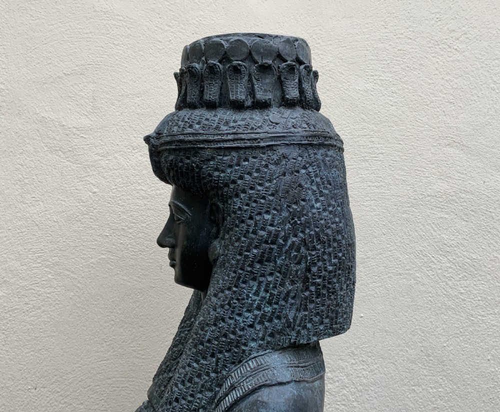 A dark green patinated bronze bust of Cleopatra holding an asp, mounted on a rectangular pink marble base. View XVII