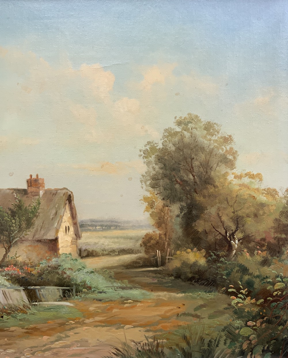 An oil painting depicting a thatched cottage along a dirt lane, housed inside an ornate swept gilt frame with scroll motifs. View V