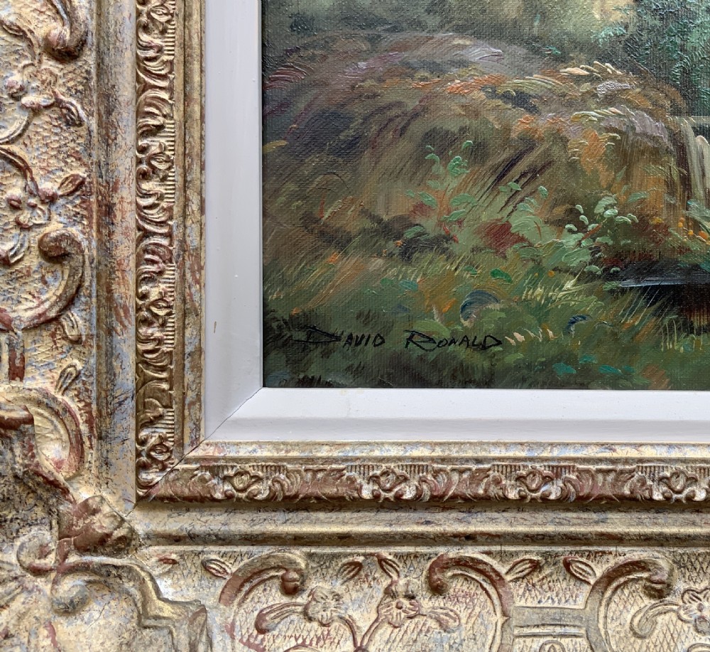 An oil painting depicting a thatched cottage along a dirt lane, housed inside an ornate swept gilt frame with scroll motifs. View VII