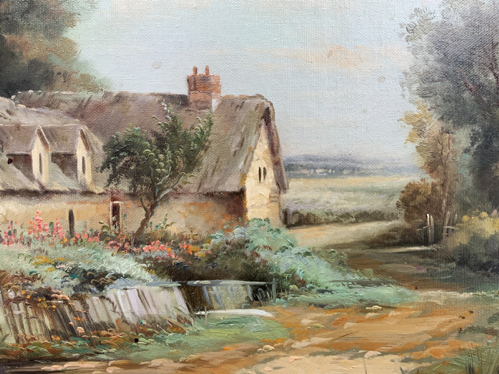 An oil painting depicting a thatched cottage along a dirt lane, housed inside an ornate swept gilt frame with scroll motifs. View X