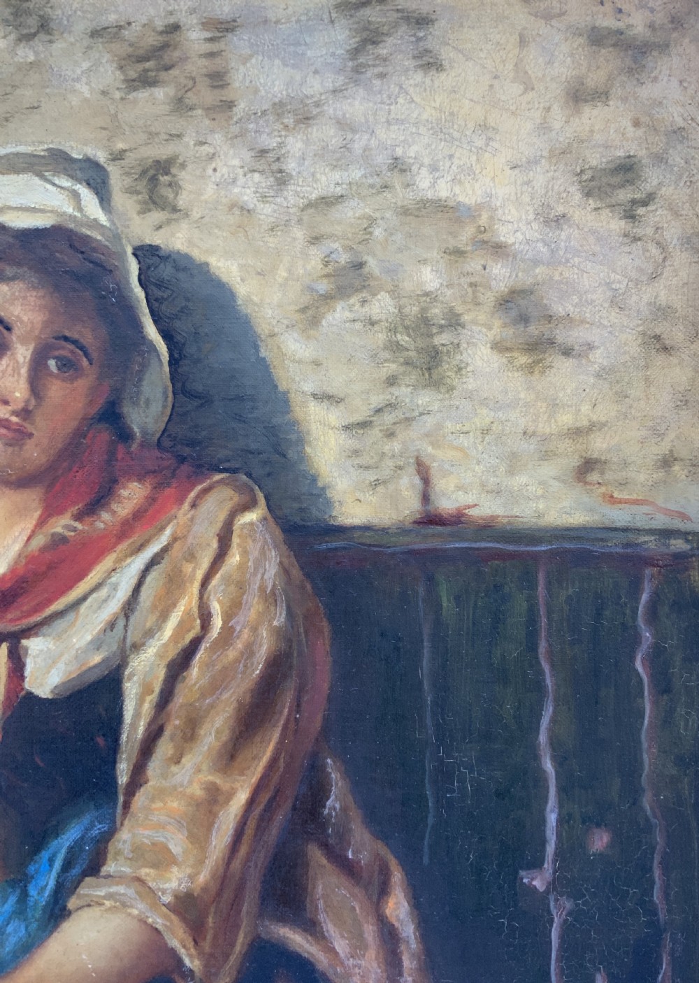 A 19th-century oil painting depicting a young Dutch fisher girl in traditional costume seated near the sea, housed within an ornate gilt wooden frame. View IX