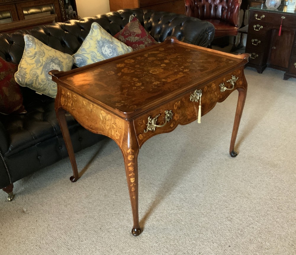 An 18th-century Dutch walnut tea table featuring floral fruitwood marquetry inlays, a tray top, brass handles, and cabriole legs. View II