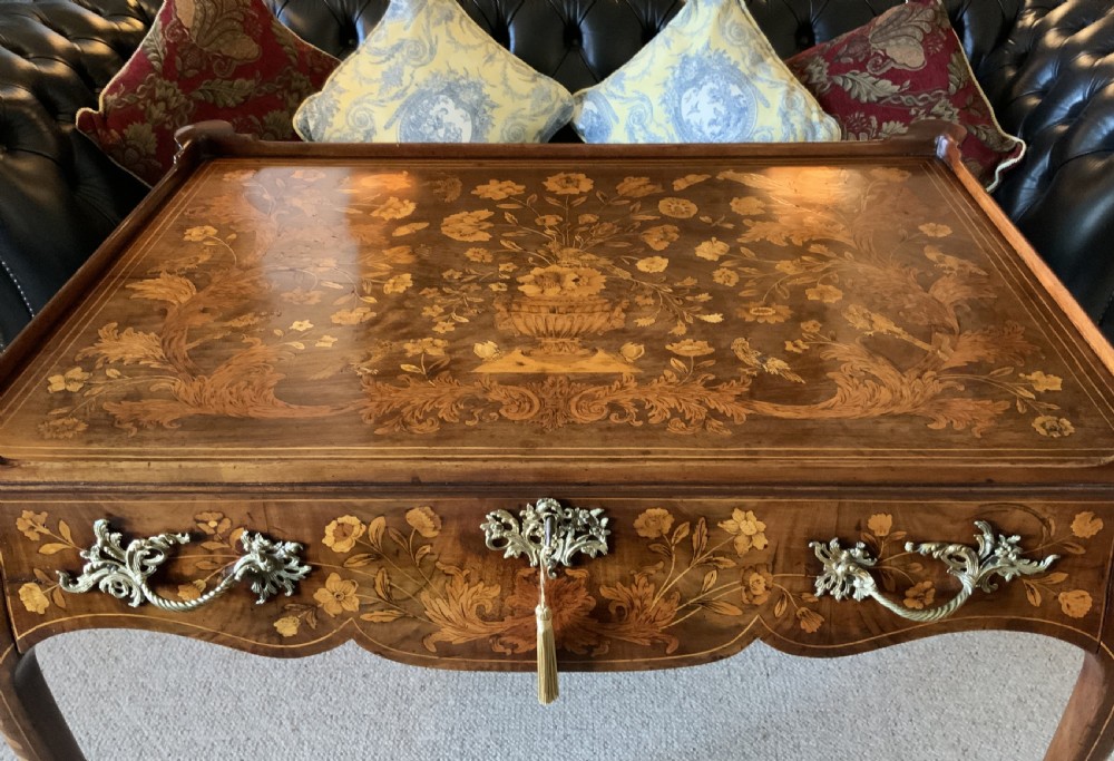 An 18th-century Dutch walnut tea table featuring floral fruitwood marquetry inlays, a tray top, brass handles, and cabriole legs. View IV