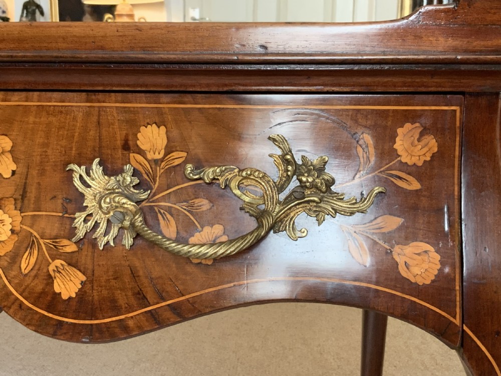 An 18th-century Dutch walnut tea table featuring floral fruitwood marquetry inlays, a tray top, brass handles, and cabriole legs. View XV