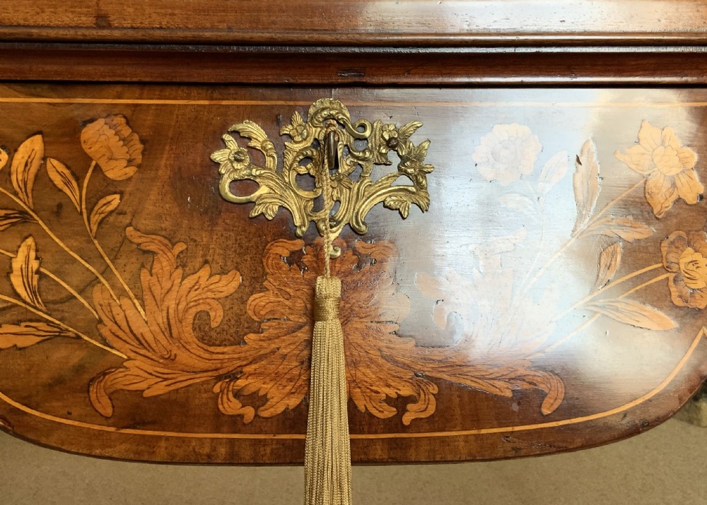An 18th-century Dutch walnut tea table featuring floral fruitwood marquetry inlays, a tray top, brass handles, and cabriole legs. View XVI