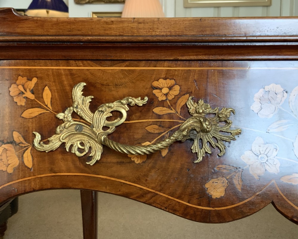 An 18th-century Dutch walnut tea table featuring floral fruitwood marquetry inlays, a tray top, brass handles, and cabriole legs. View XVII