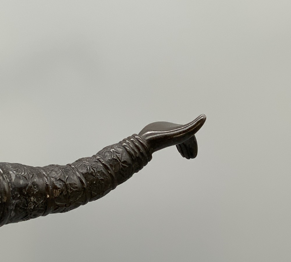 A dark bronze sculpture depicting a classical court dancer in ceremonial attire with a tall spired headdress, balanced on one foot atop an octagonal stepped base. View XV