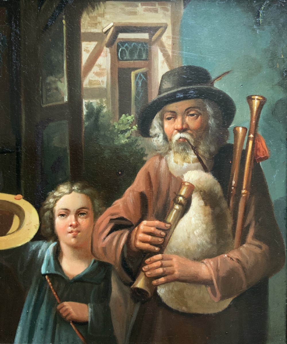 An antique oil painting in a deep burr wood frame depicting an older bearded musician playing a bagpipe alongside a child holding an extended hat. View II