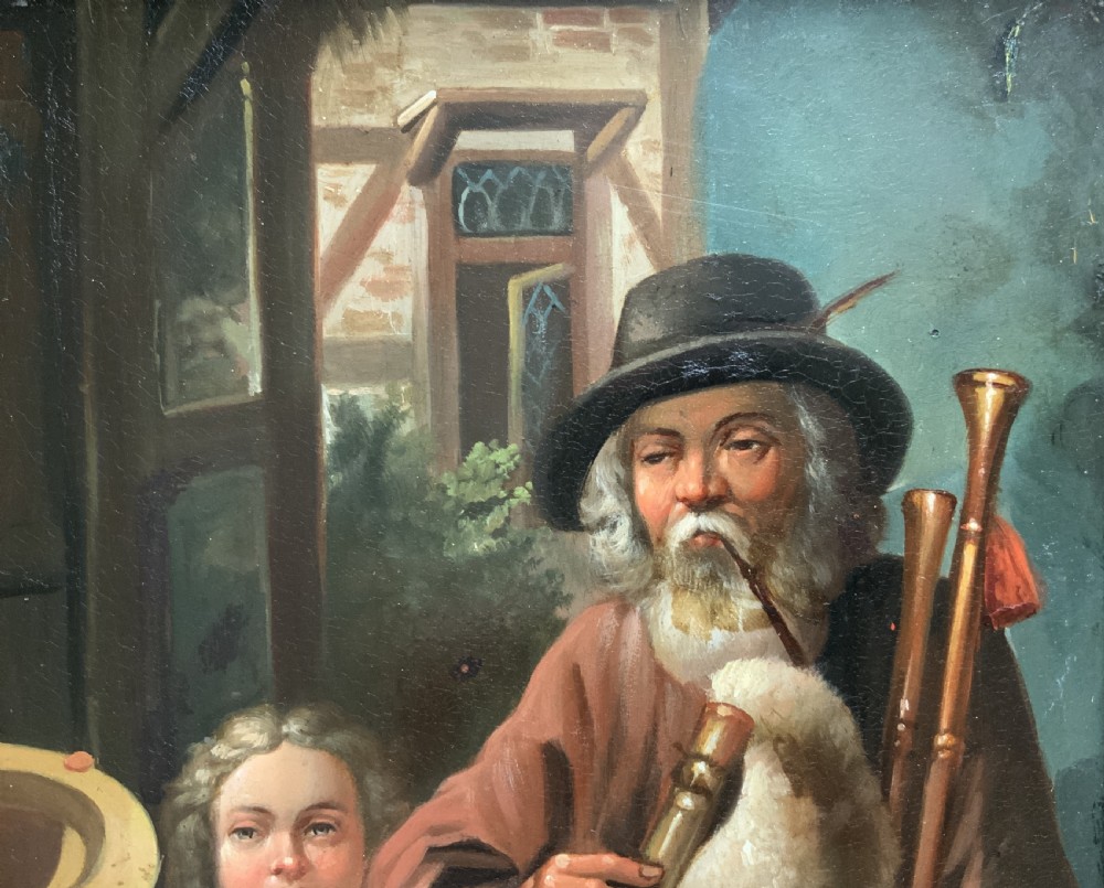 An antique oil painting in a deep burr wood frame depicting an older bearded musician playing a bagpipe alongside a child holding an extended hat. View III