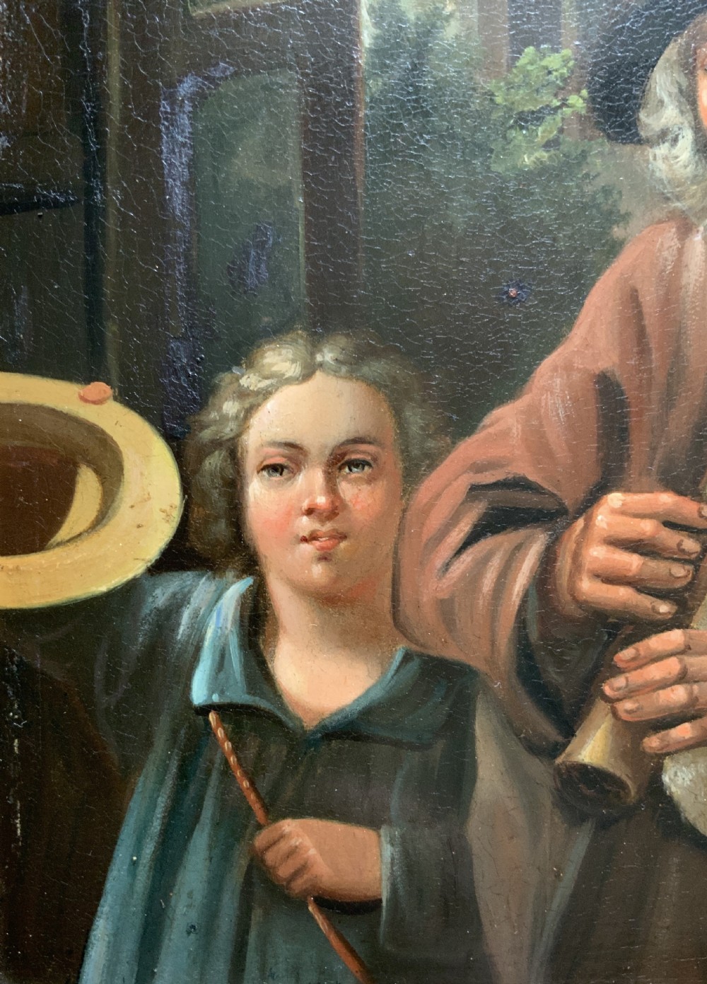 An antique oil painting in a deep burr wood frame depicting an older bearded musician playing a bagpipe alongside a child holding an extended hat. View V