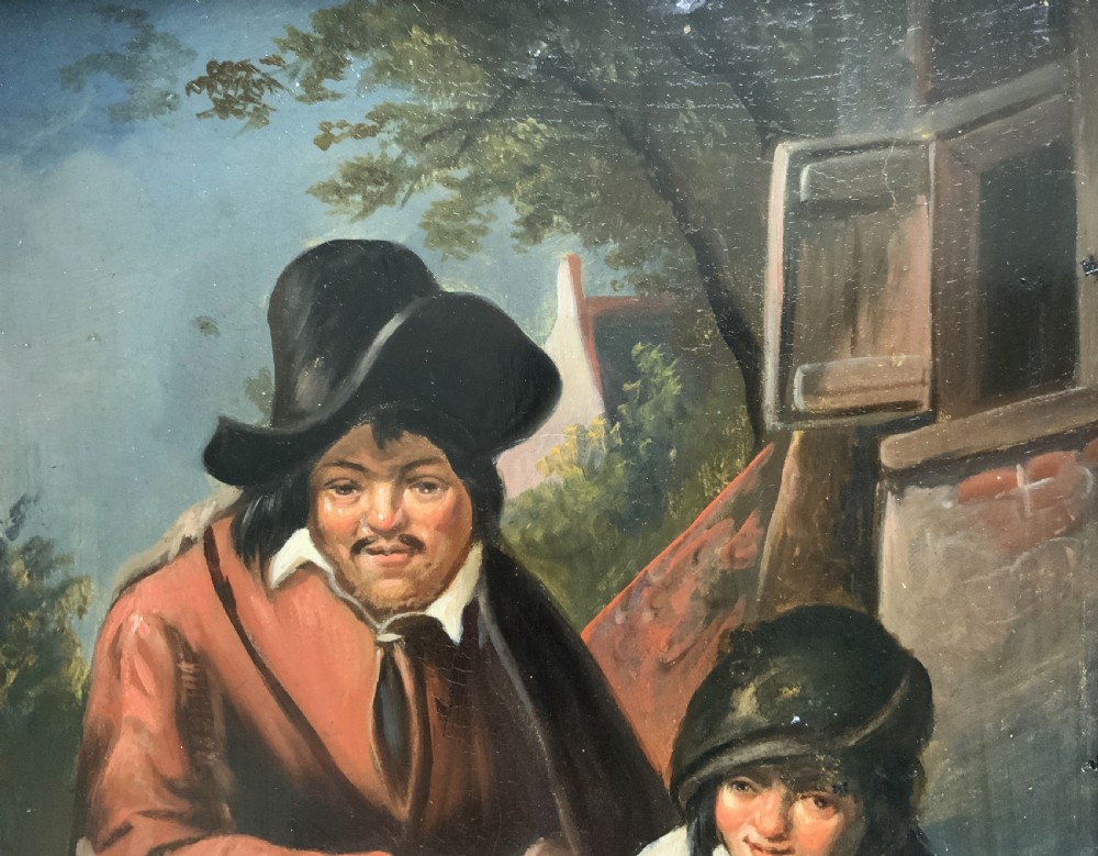 An antique oil painting depicting two musicians, a man and a boy playing a violin, set in a wide wooden frame with a gilded inner moulding. View V
