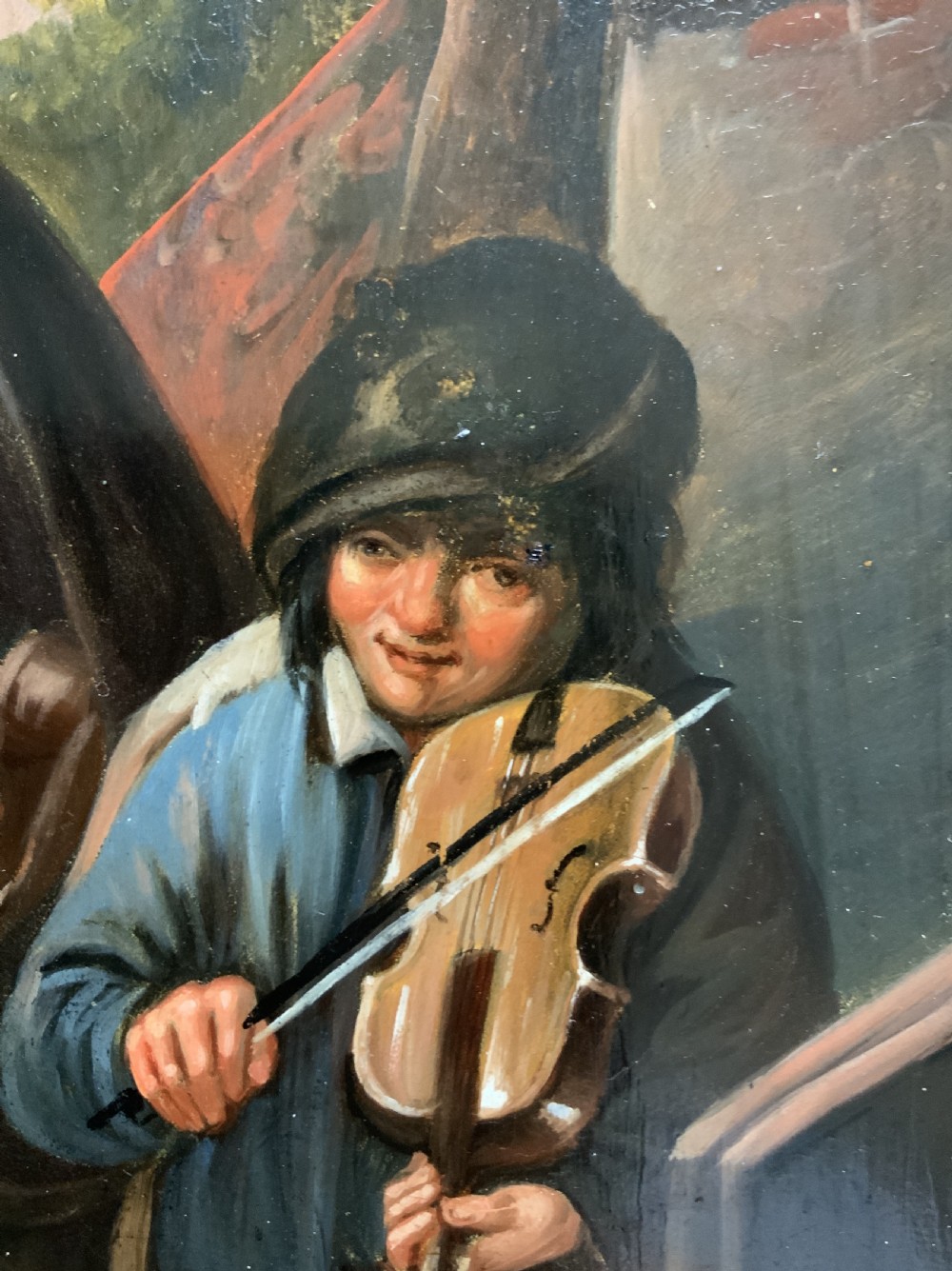 An antique oil painting depicting two musicians, a man and a boy playing a violin, set in a wide wooden frame with a gilded inner moulding. View VIII