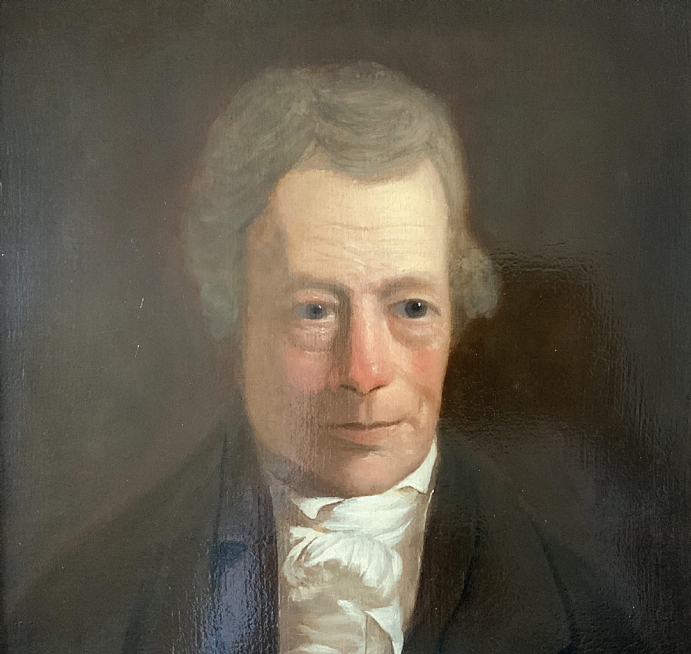 An early nineteenth-century portrait painting of a gentleman wearing a white cravat and dark coat, set within a carved gilt frame. View V