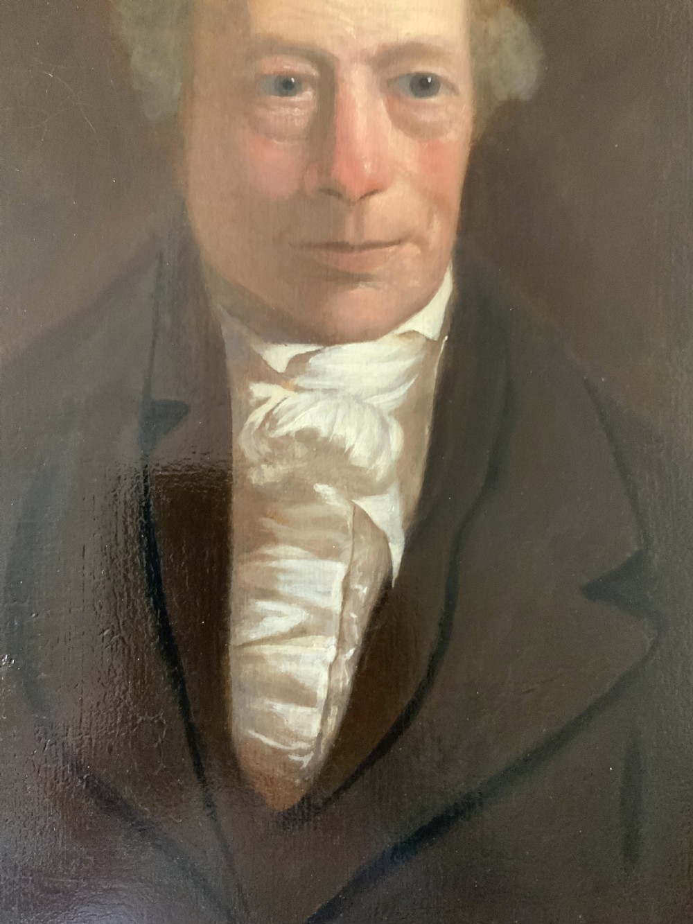 An early nineteenth-century portrait painting of a gentleman wearing a white cravat and dark coat, set within a carved gilt frame. View VII