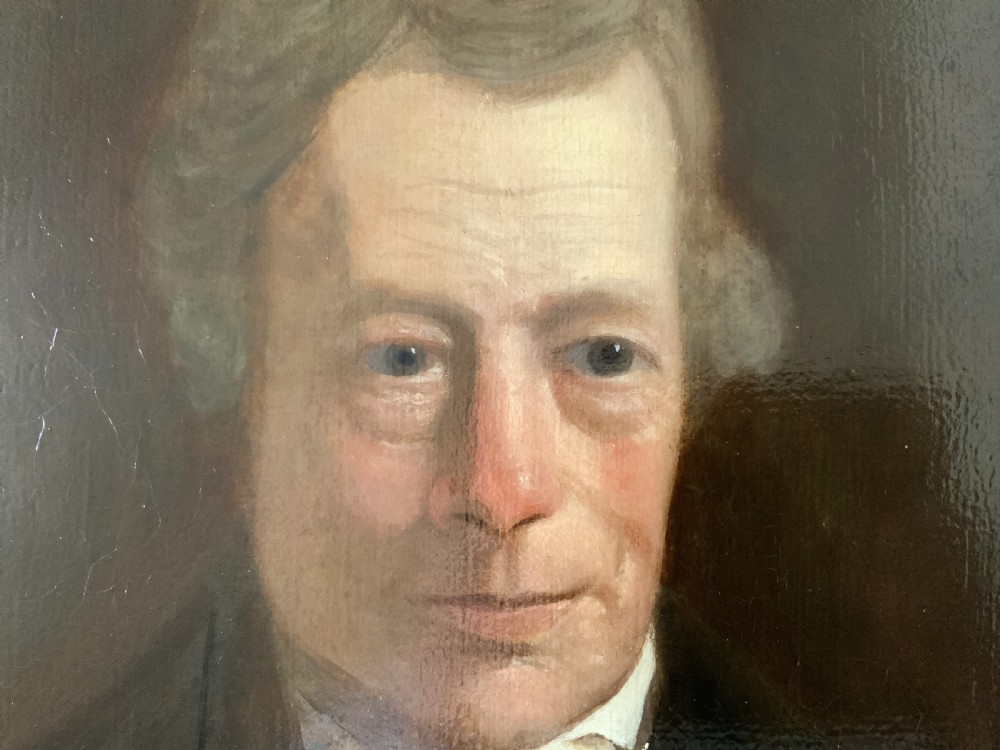 An early nineteenth-century portrait painting of a gentleman wearing a white cravat and dark coat, set within a carved gilt frame. View VIII