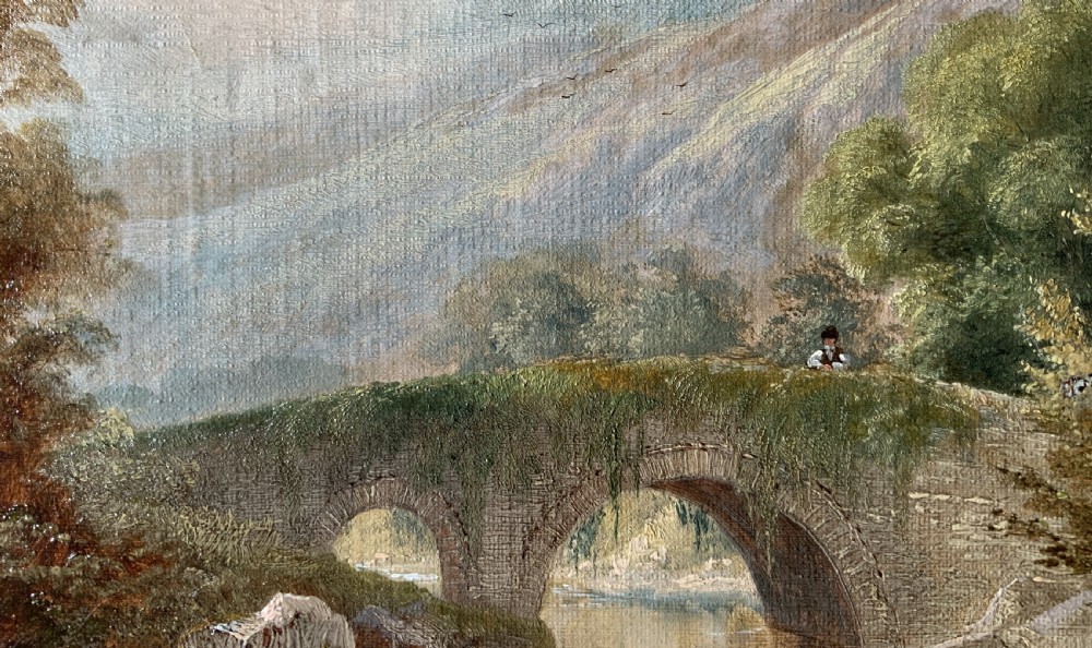 A framed 19th-century oil painting depicting an arched stone bridge crossing a river amidst trees and distant mountains. View VII