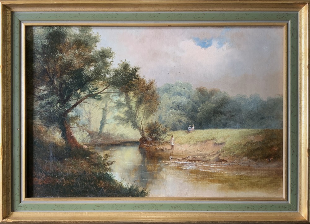 A 19th-century landscape oil painting depicting a river scene with trees and figures along the bank, housed in a green and gold moulded frame.