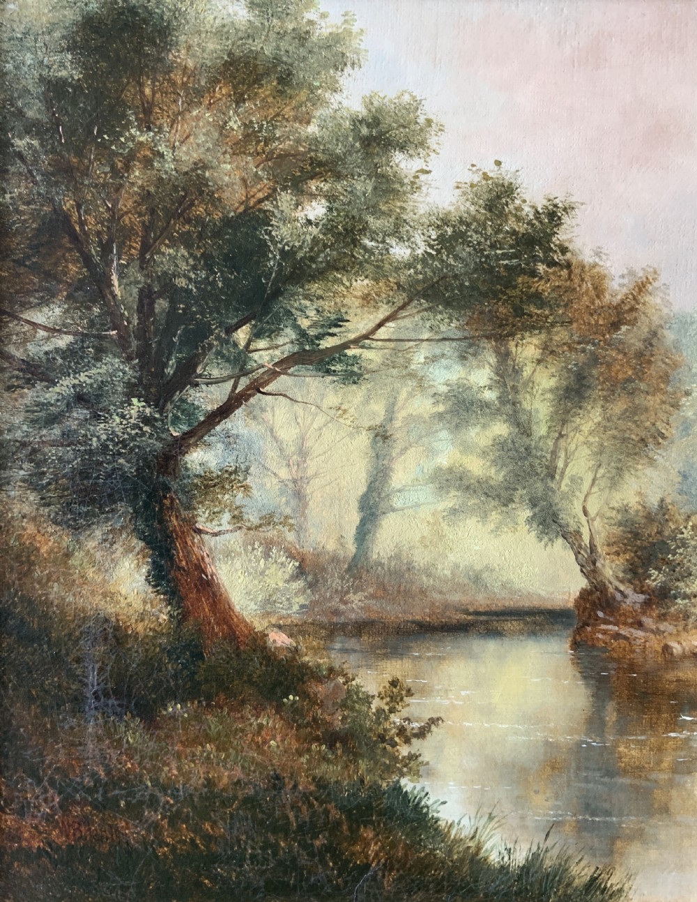 A 19th-century landscape oil painting depicting a river scene with trees and figures along the bank, housed in a green and gold moulded frame. View VI